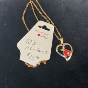 A gold necklace with a heart on it