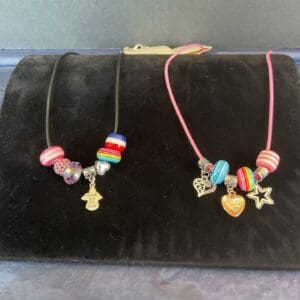 A black bag with two necklaces on it