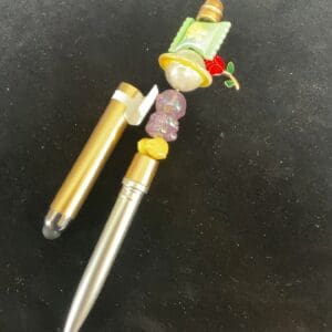 A pen with a character on it and some beads