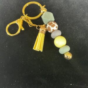 A yellow key chain with a tassel and beads.