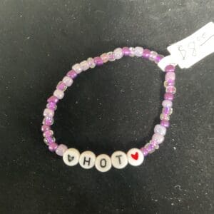 Purple beaded bracelet: "HOT" with hearts.